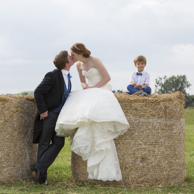 Bride and Groom kissing on Hay Bales